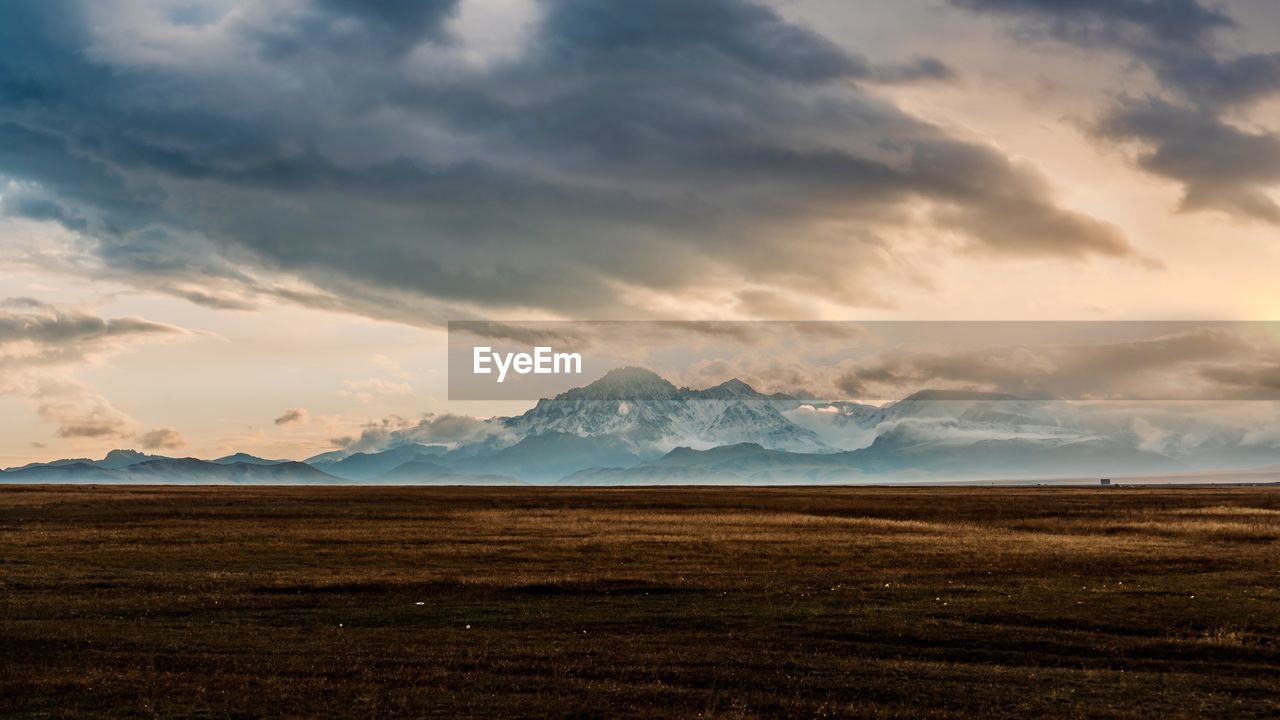 horizon, environment, sky, landscape, cloud, mountain, scenics - nature, dawn, beauty in nature, morning, nature, land, sunrise, mountain range, sunlight, dramatic sky, travel destinations, sea, no people, plain, water, snow, travel, tranquility, cold temperature, winter, tranquil scene, outdoors, cloudscape, tourism, grass, non-urban scene, storm, rural scene, moody sky, awe, dramatic landscape