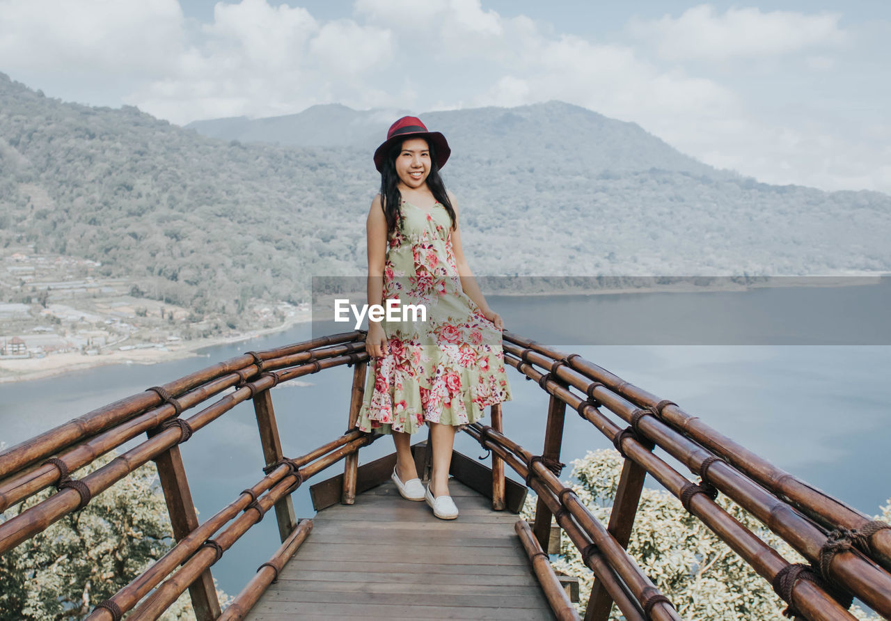 Young pretty asian woman feeling relax with ocean and mountain view in wanagiri, bali. 