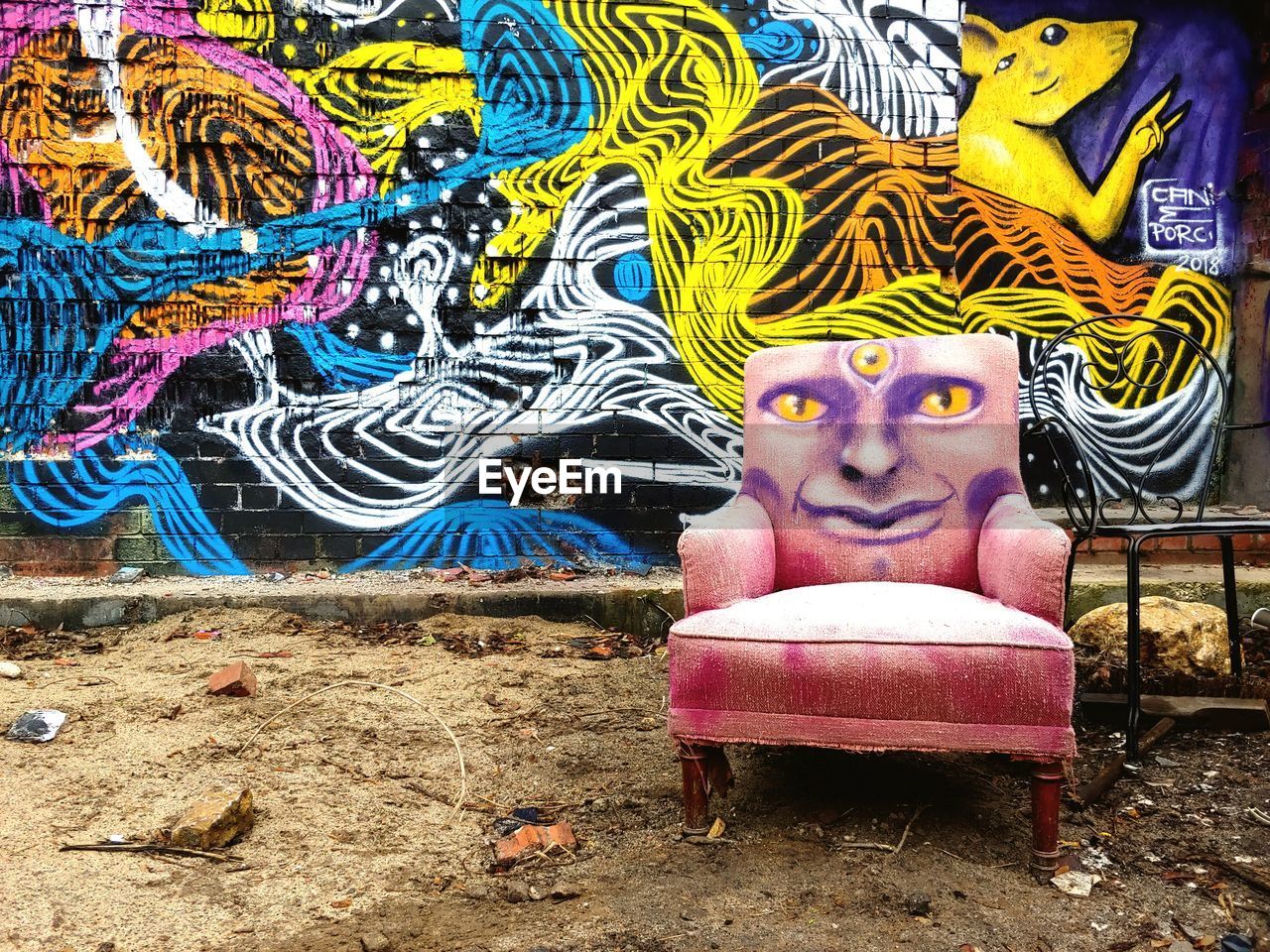 PORTRAIT OF WOMAN RELAXING ON MULTI COLORED GRAFFITI ON WALL