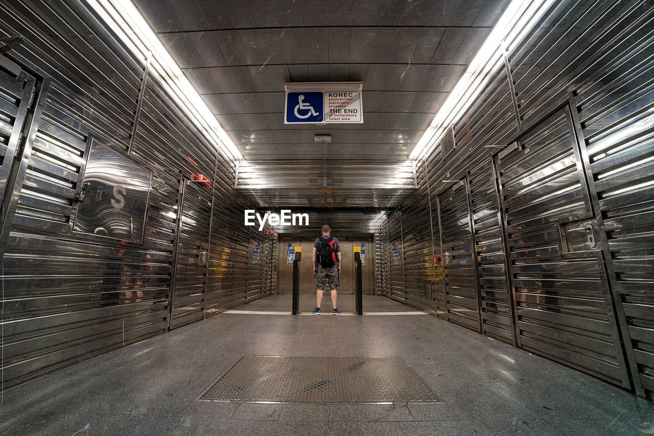 Rear view of man standing in walkway