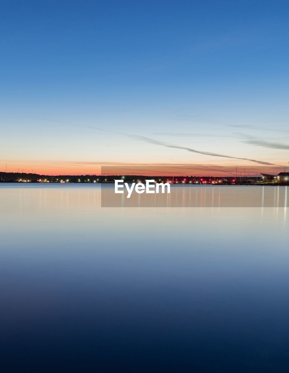 Scenic view of lake against blue sky during sunset