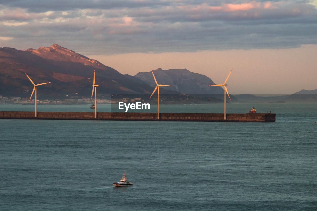 SCENIC VIEW OF SEA AGAINST MOUNTAINS