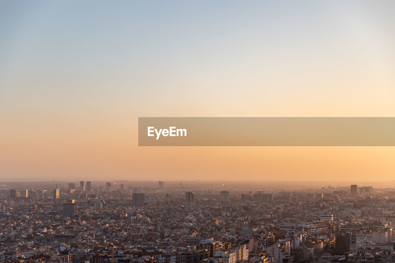 HIGH ANGLE VIEW OF BUILDINGS AT SUNSET