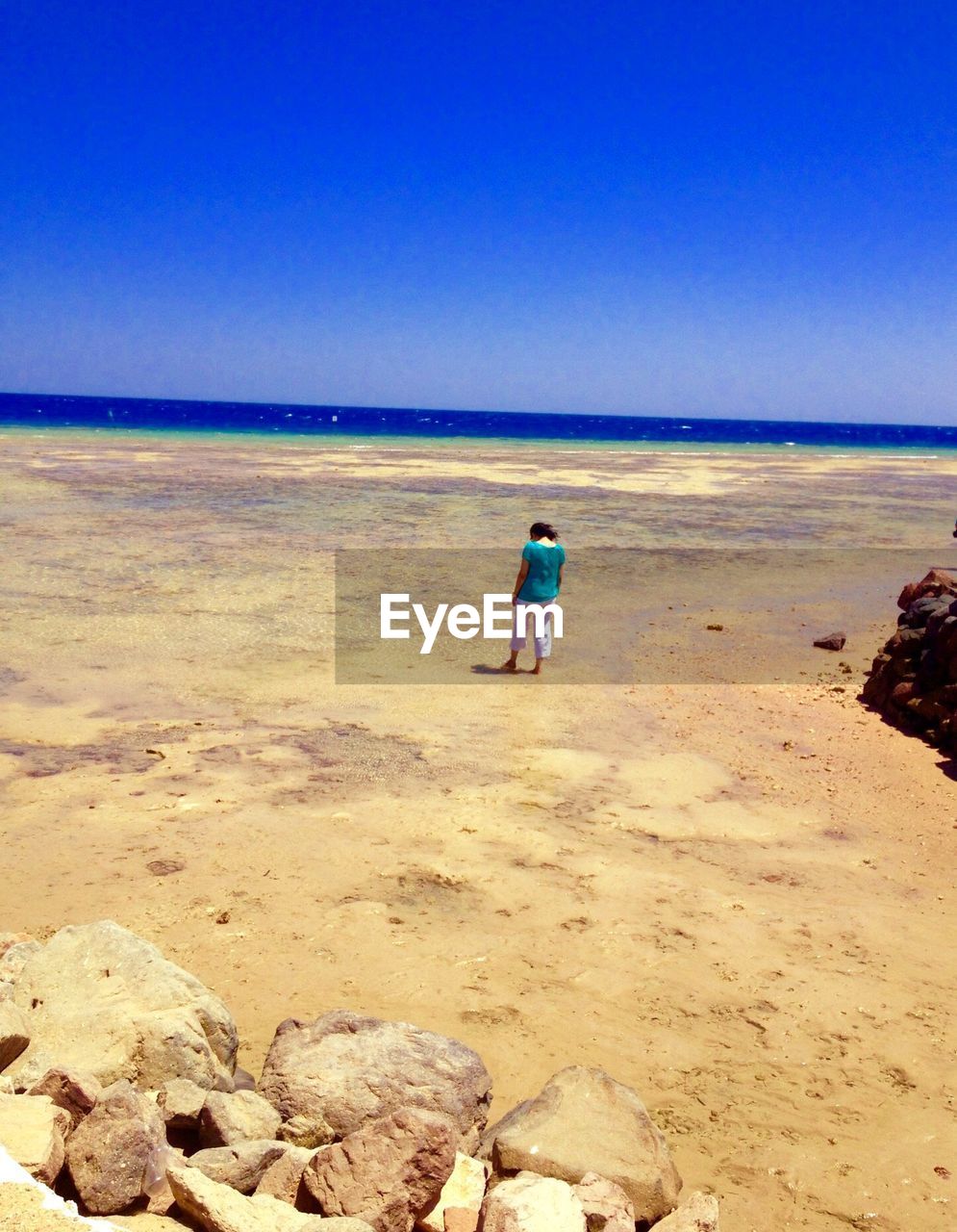 High angle view of woman standing at beach against sky