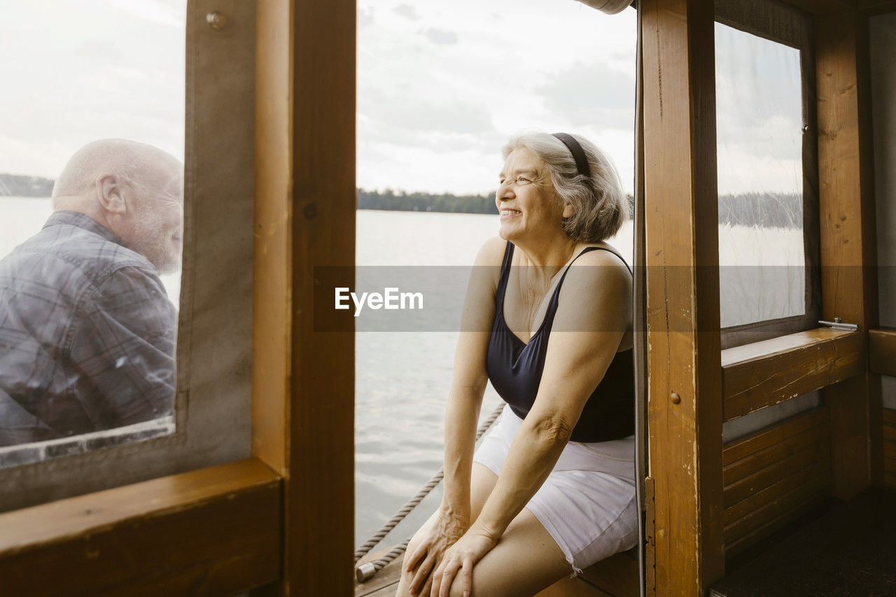 Happy senior woman sitting with man at houseboat