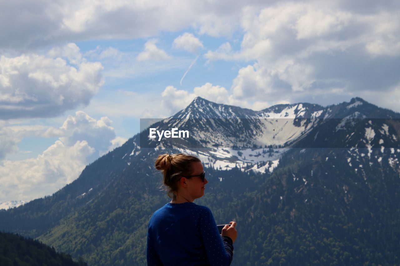 Woman standing against snowcapped mountain