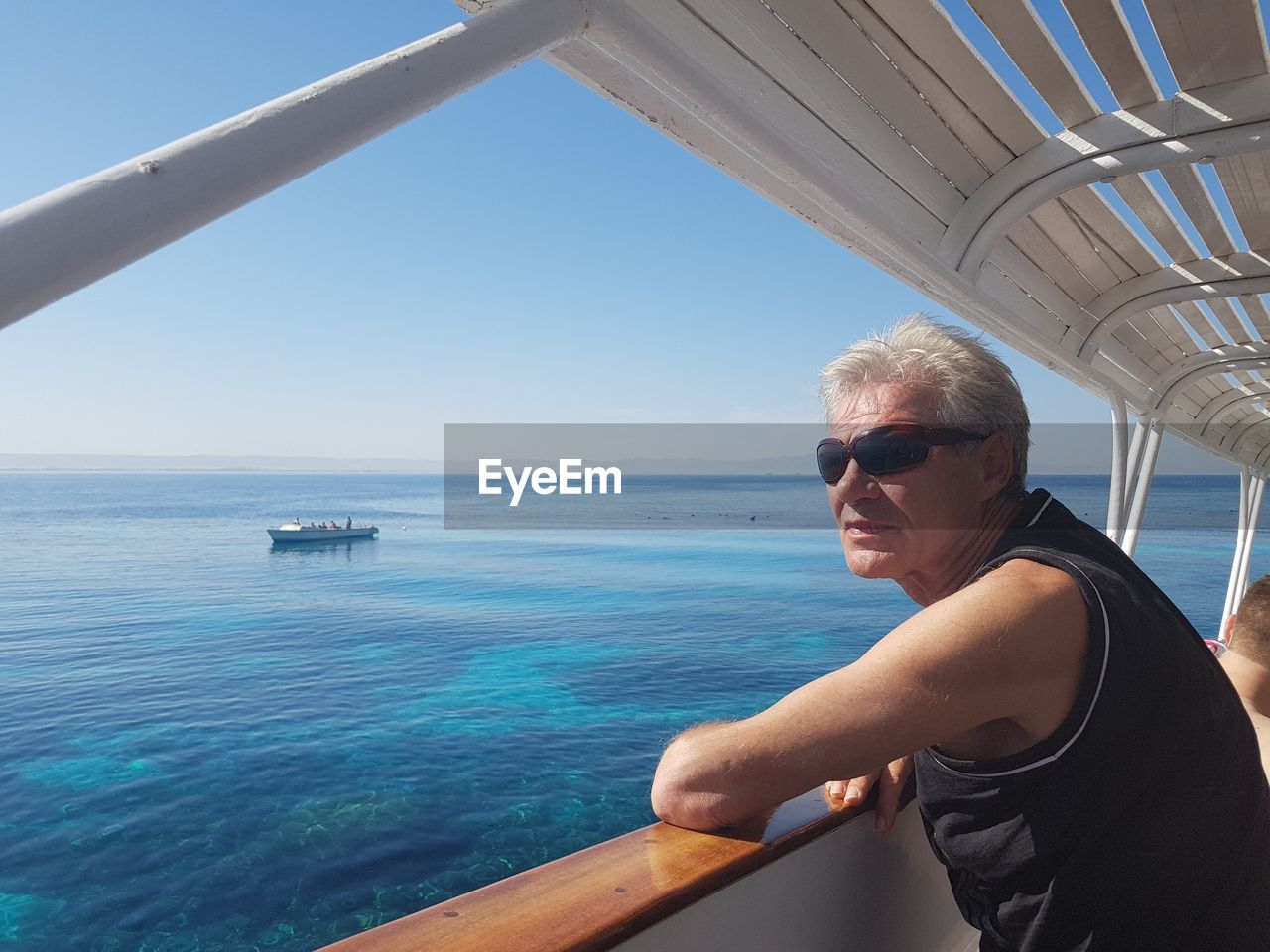 Man in sunglasses traveling in yacht on sea against sky
