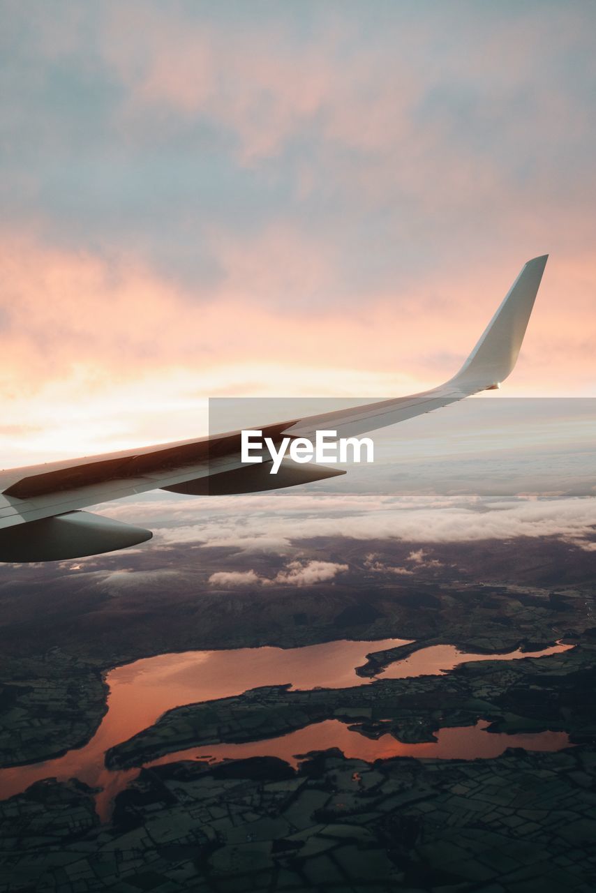 CLOSE-UP OF AIRPLANE WING OVER CLOUDS