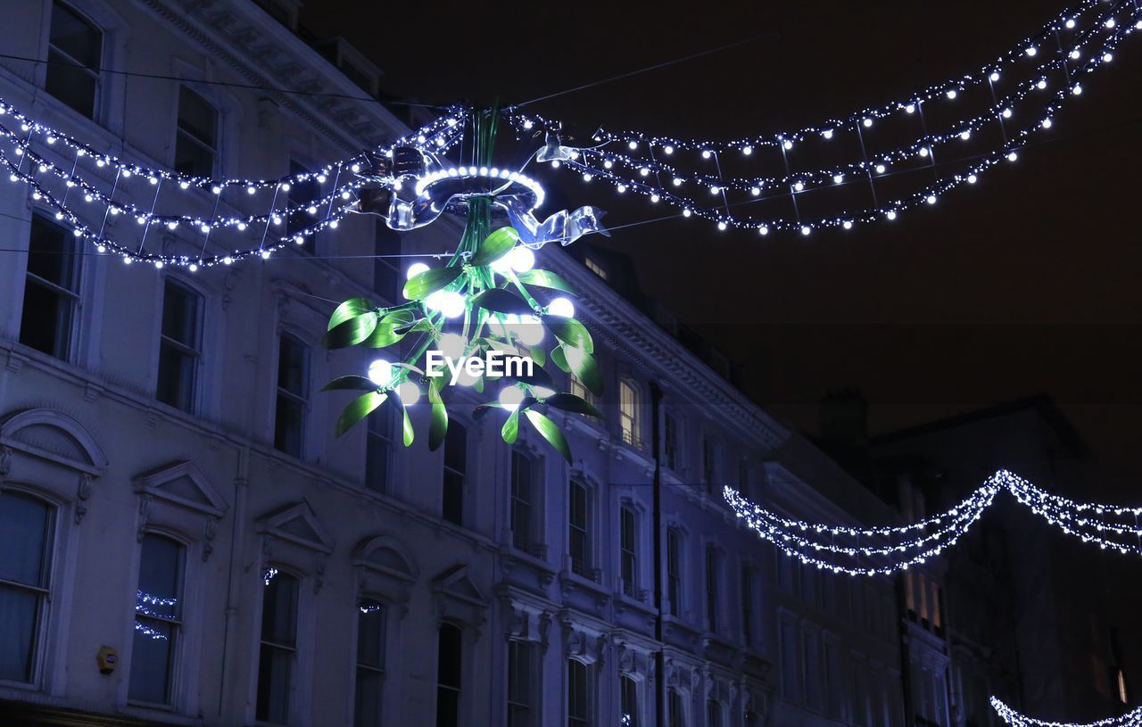 LOW ANGLE VIEW OF CHRISTMAS TREE AGAINST SKY AT NIGHT