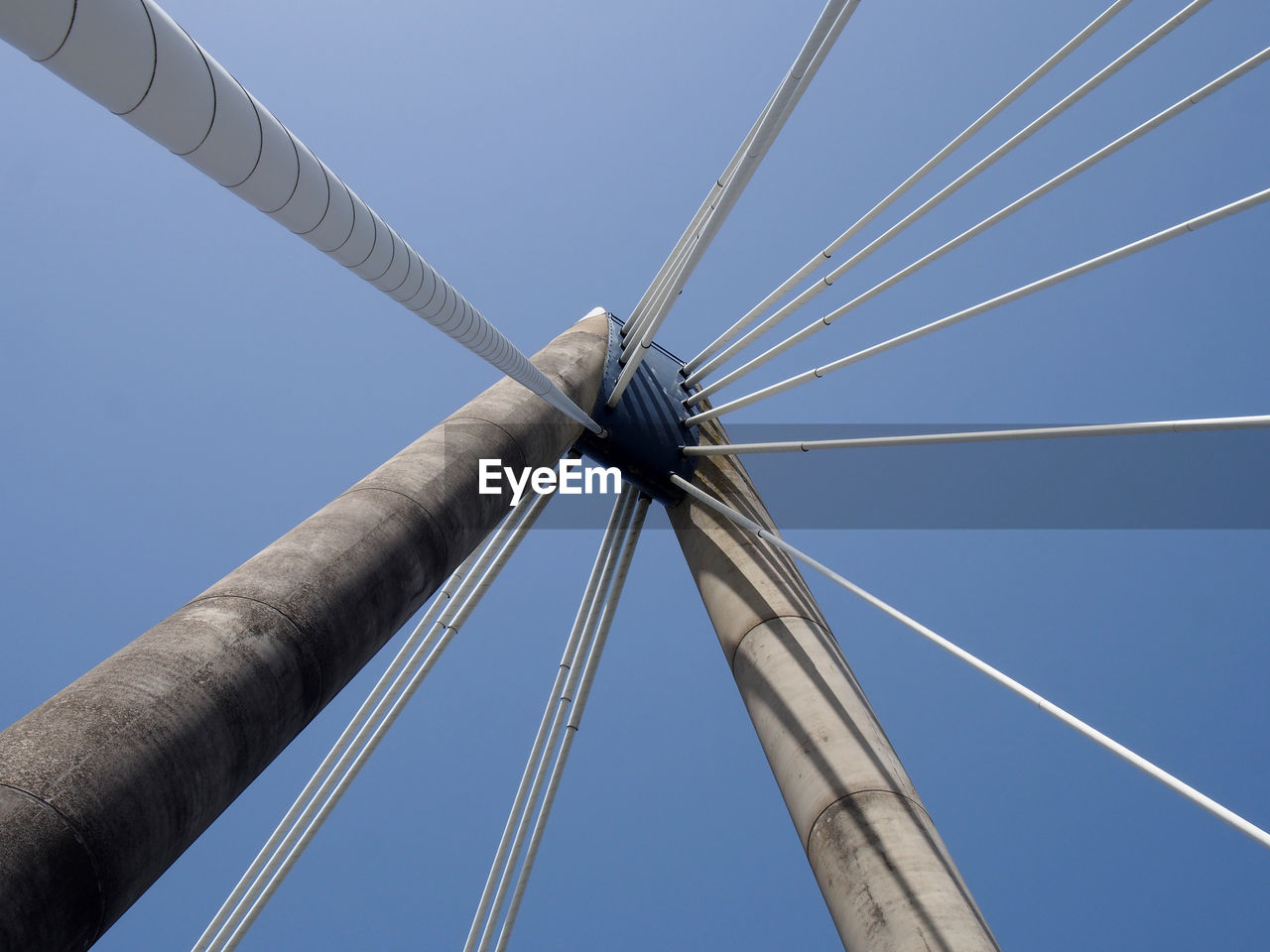 A close up of the supports and cables of the suspension bridge in southport against a blue sky