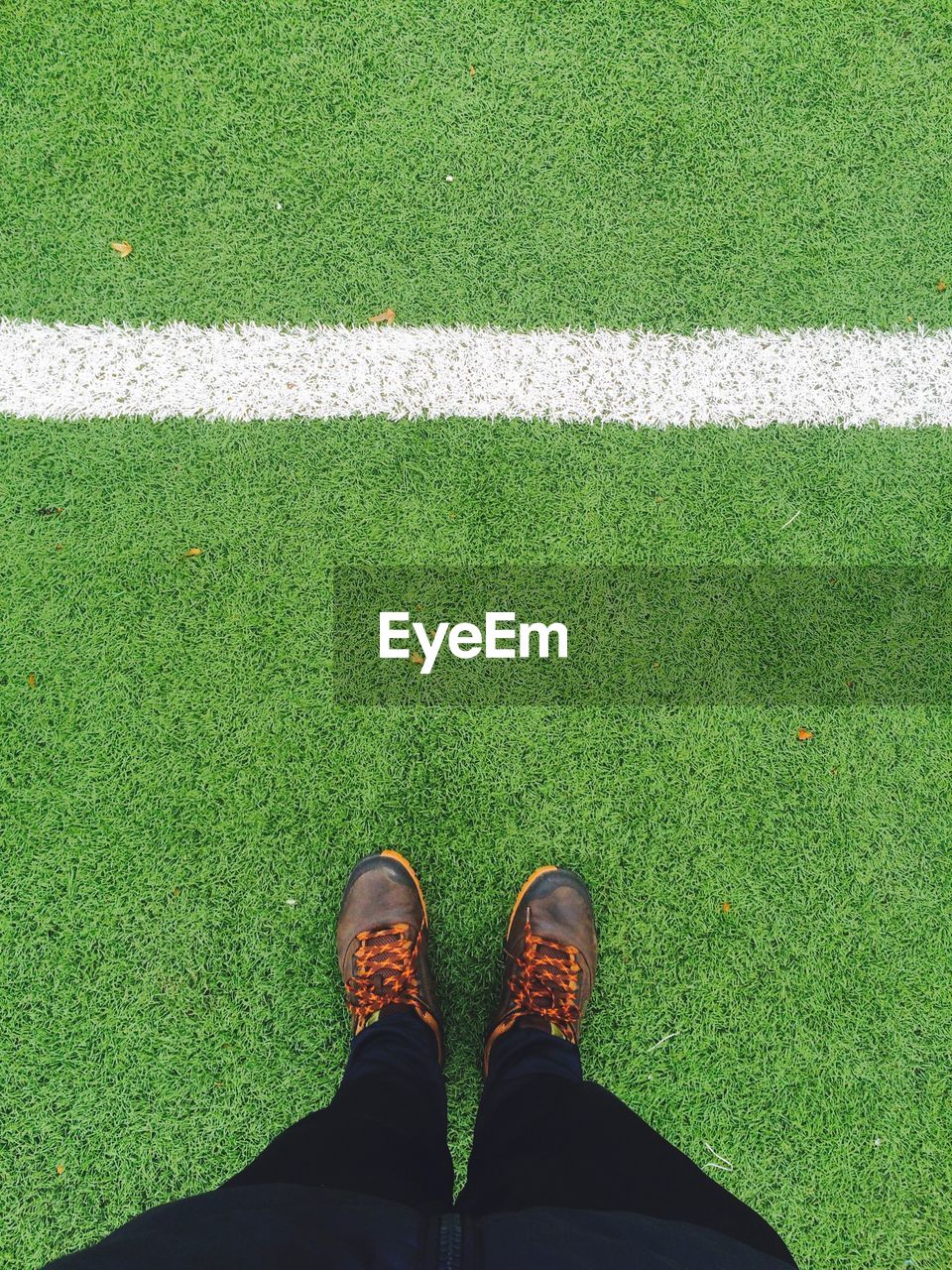 Low section of person standing on soccer field
