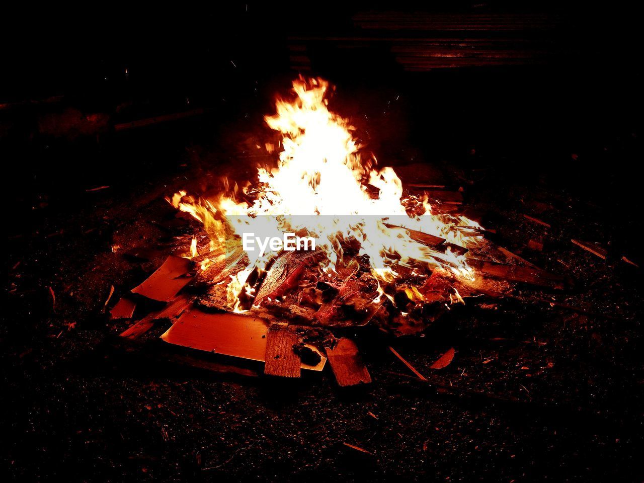 BONFIRE ON WOODEN STRUCTURE ON FIELD