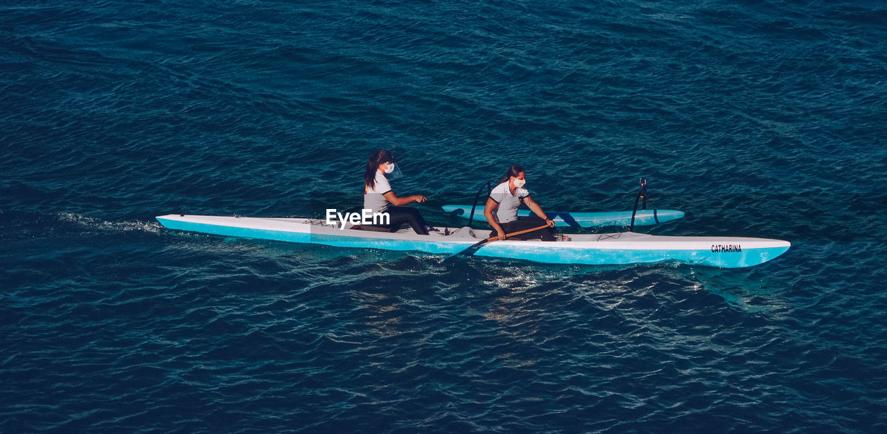 HIGH ANGLE VIEW OF PEOPLE AT SEA