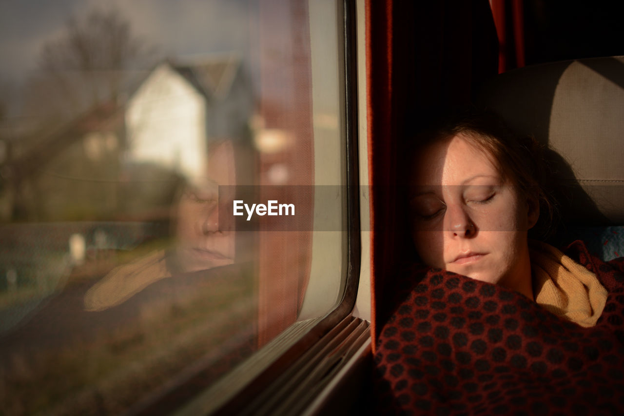 Woman sleeping while sitting in train