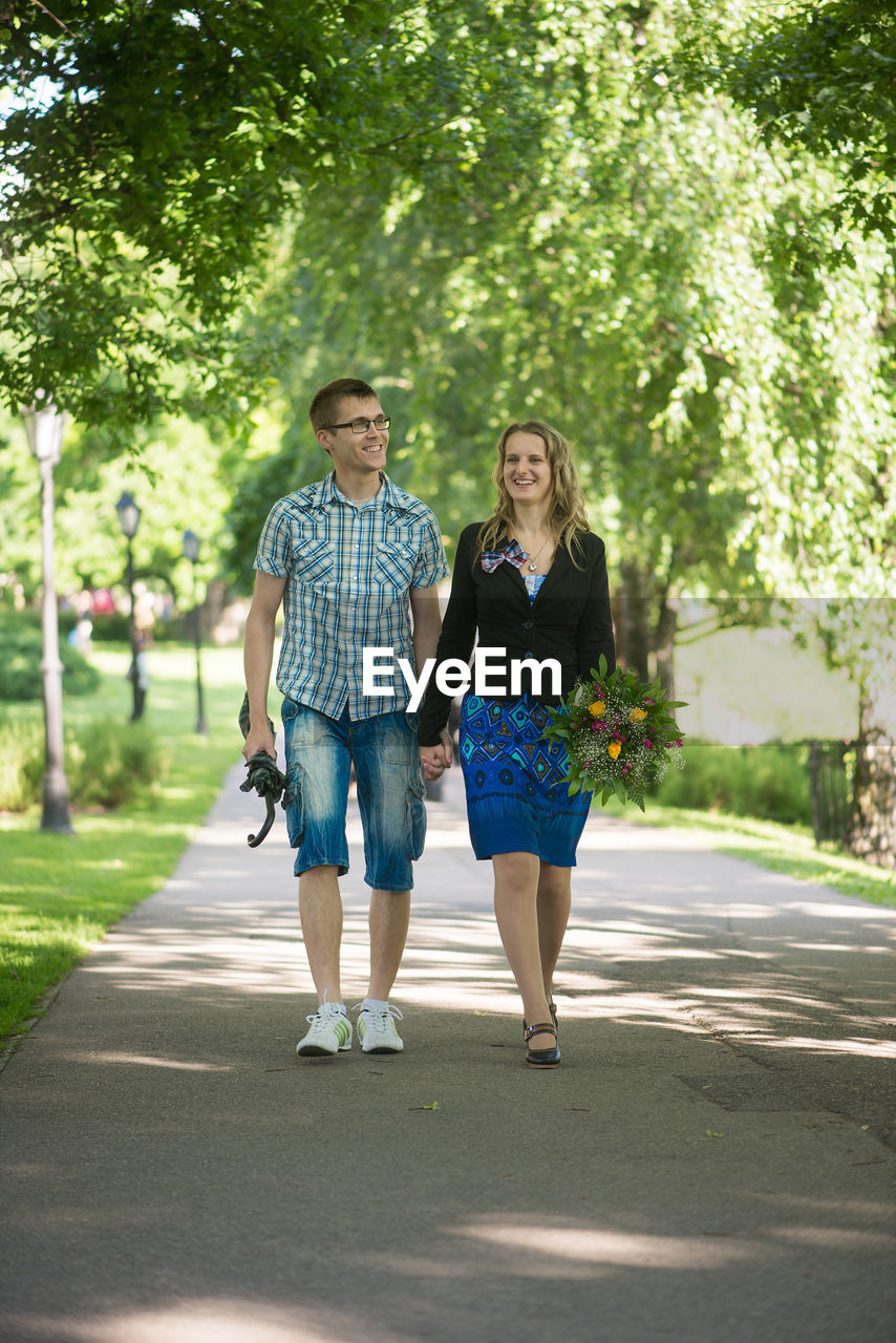 Couple holding hands while walking at park