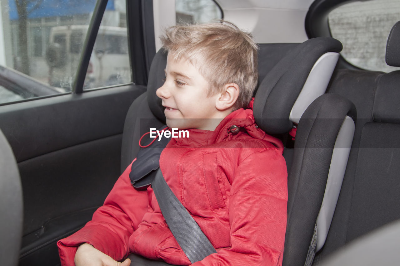 View of boy sitting in car
