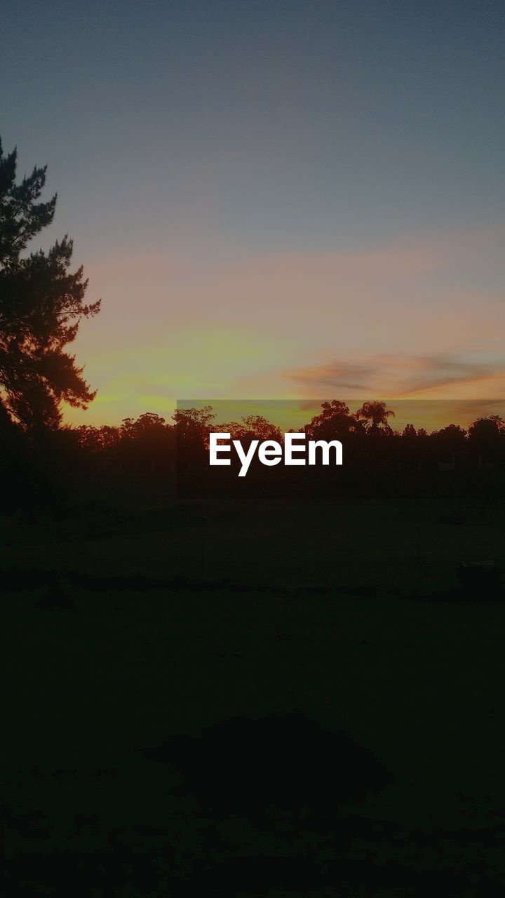 SCENIC VIEW OF SILHOUETTE FIELD AGAINST SKY DURING SUNSET