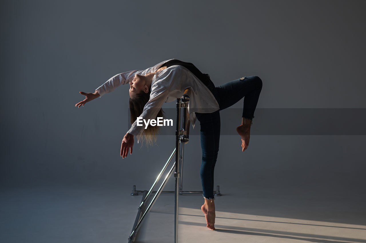 Caucasian woman posing at the ballet barre. 