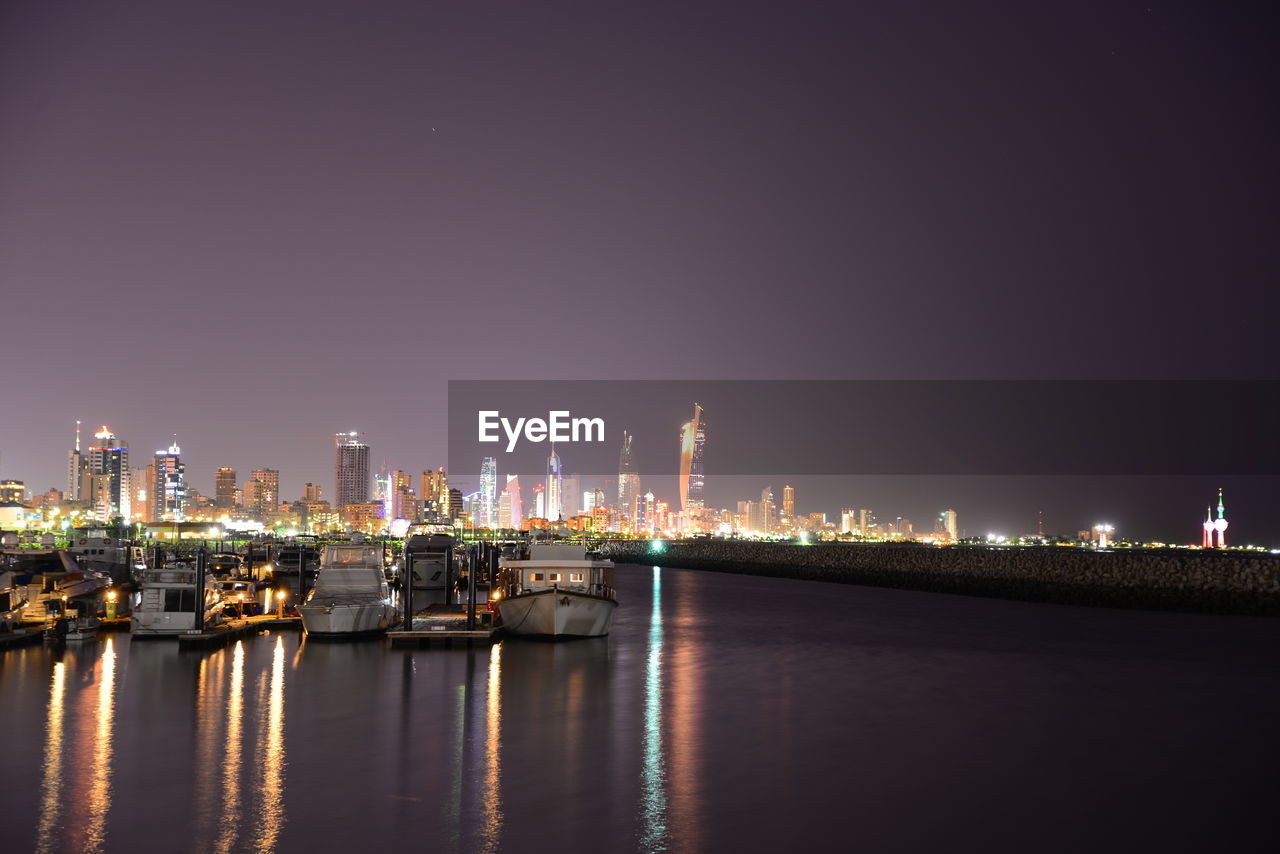 Illuminated cityscape against sky at night