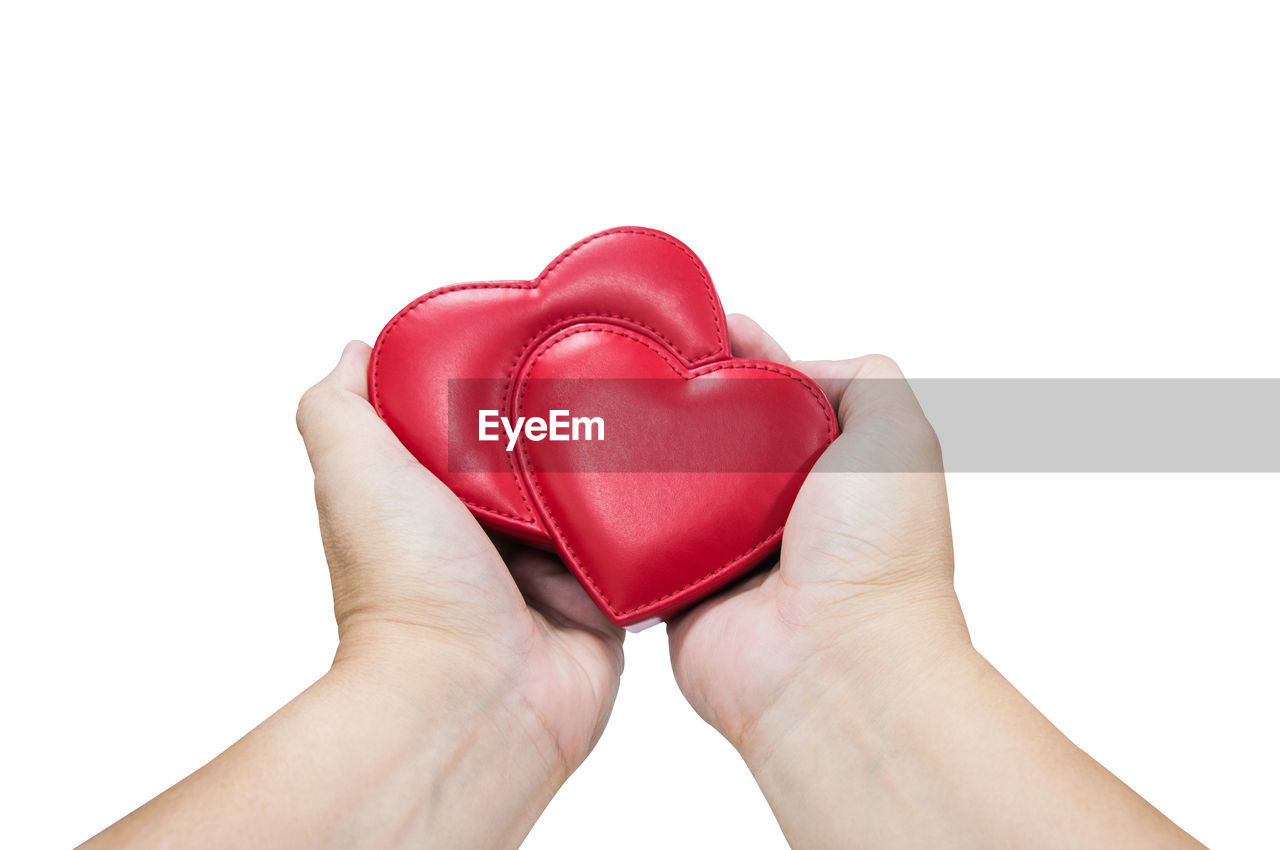 CLOSE-UP OF HUMAN HAND HOLDING HEART SHAPE AGAINST WHITE BACKGROUND