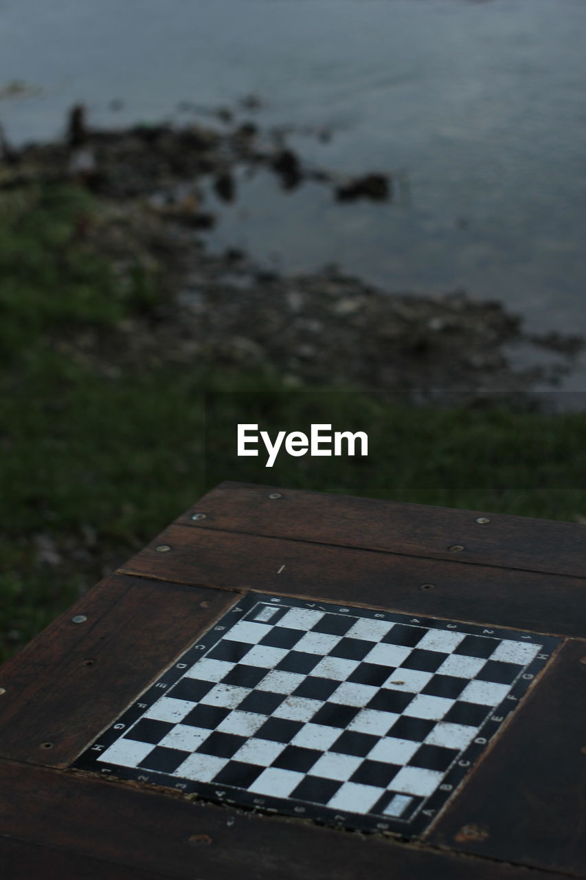 High angle view of wooden chess board on lakeshore