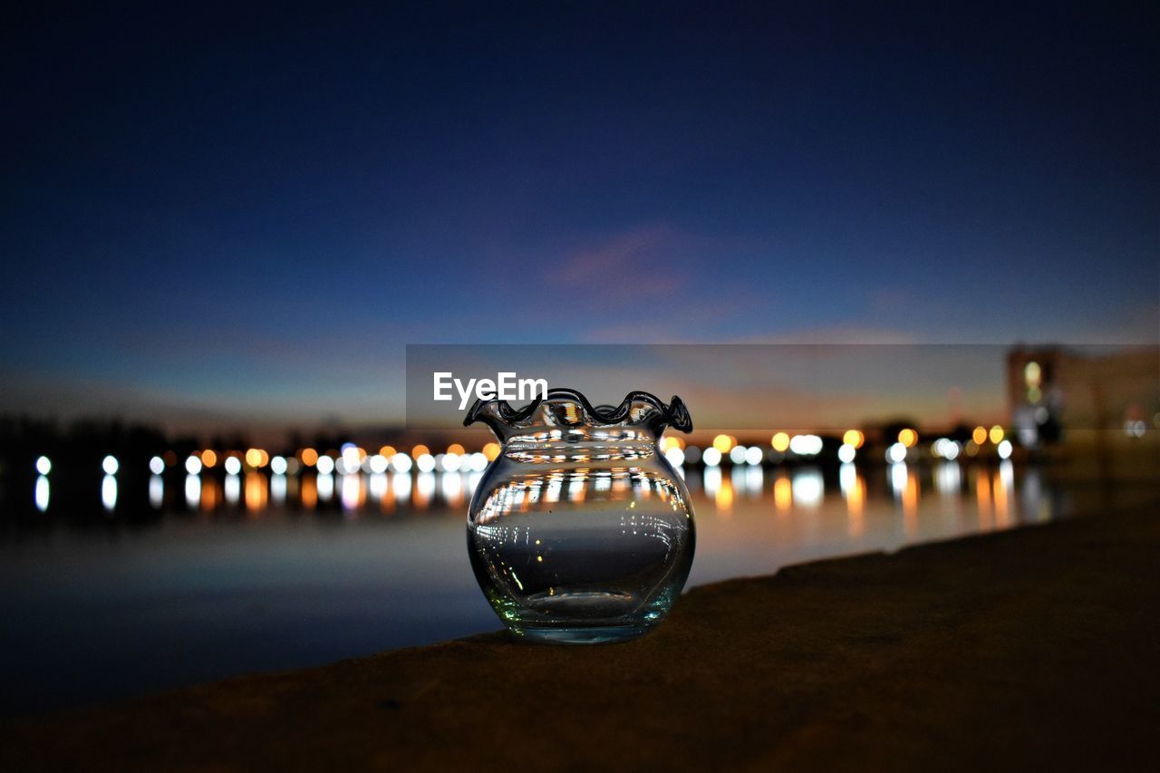 CLOSE-UP OF ILLUMINATED LIGHT BULB ON BEACH