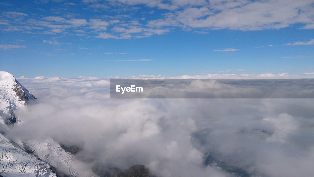 Aerial view of clouds over landscape against blue sky