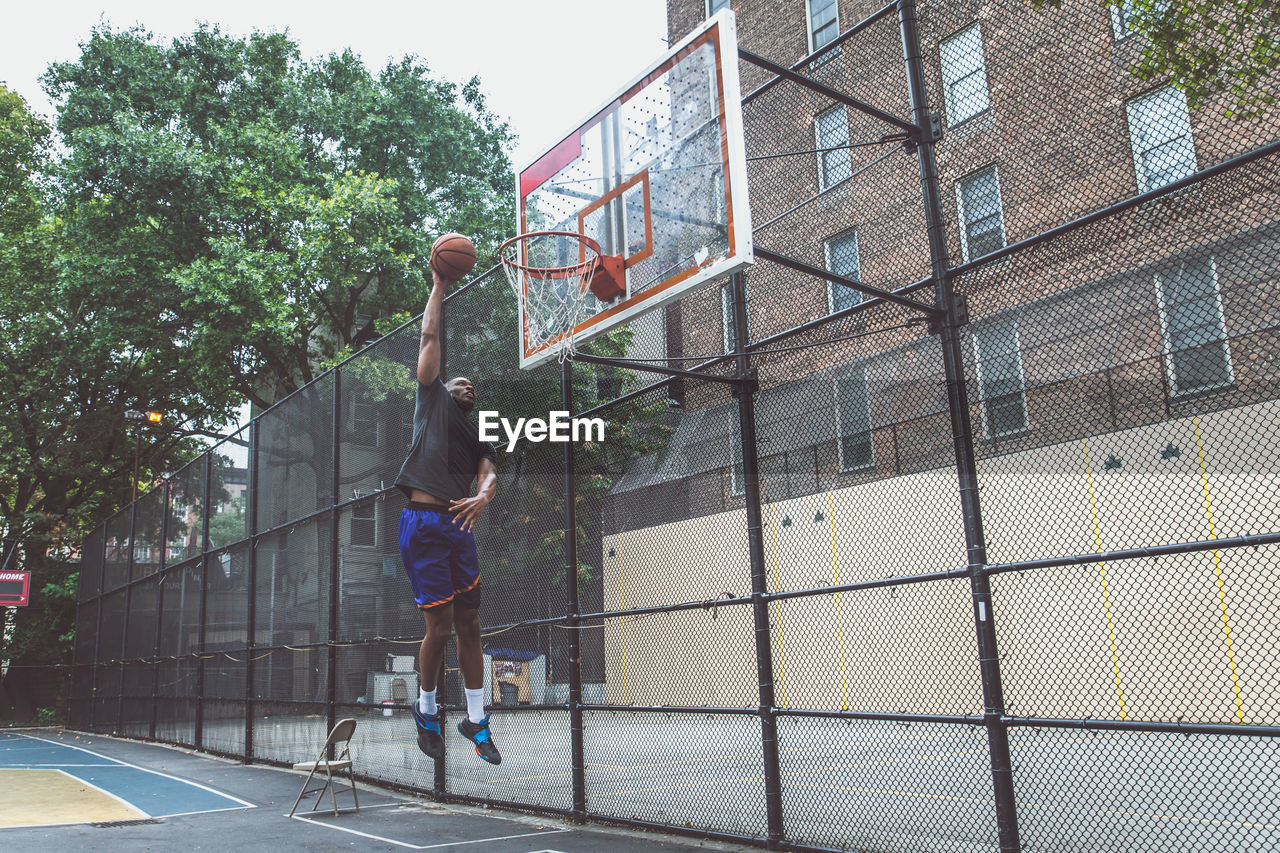 Young man playing basketball in court