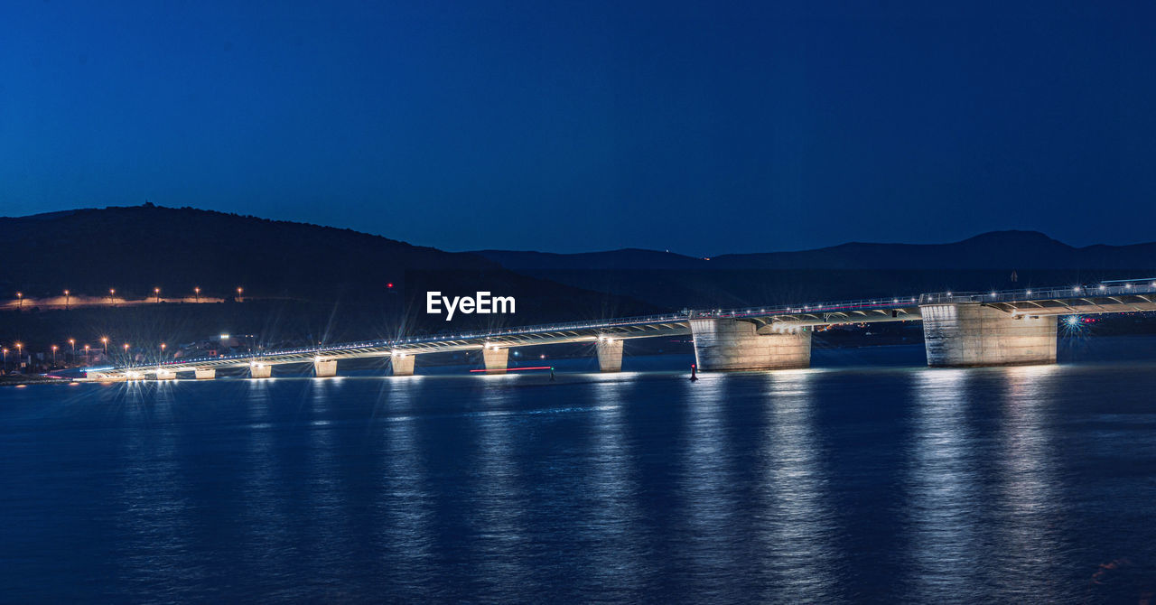 pier over river against clear sky at night