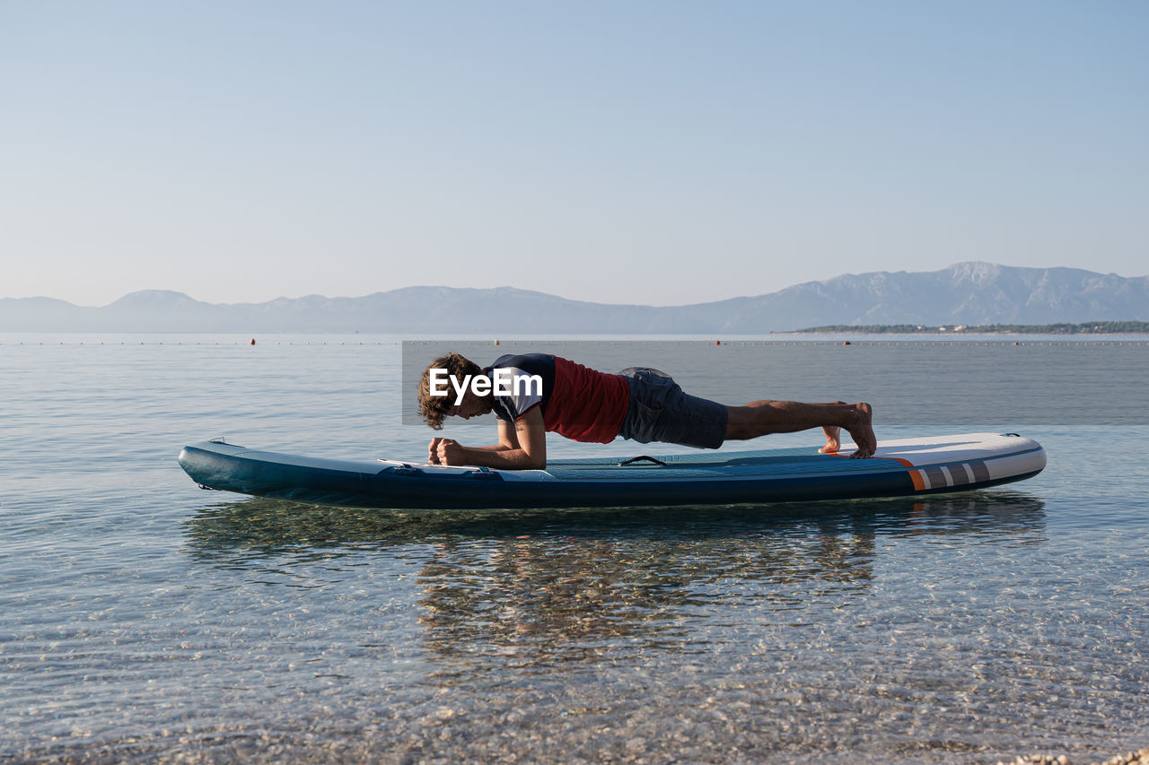 Man in boat on sea against clear sky