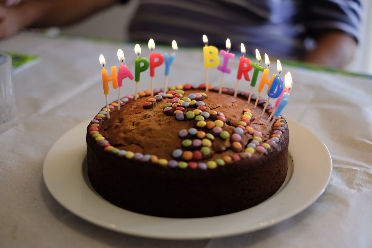 Close-up of illuminated birthday candles on cake