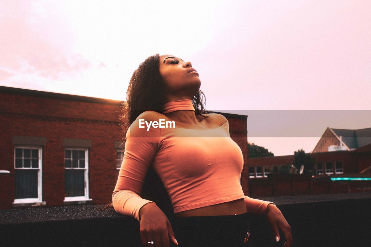 Woman standing on terrace against sky