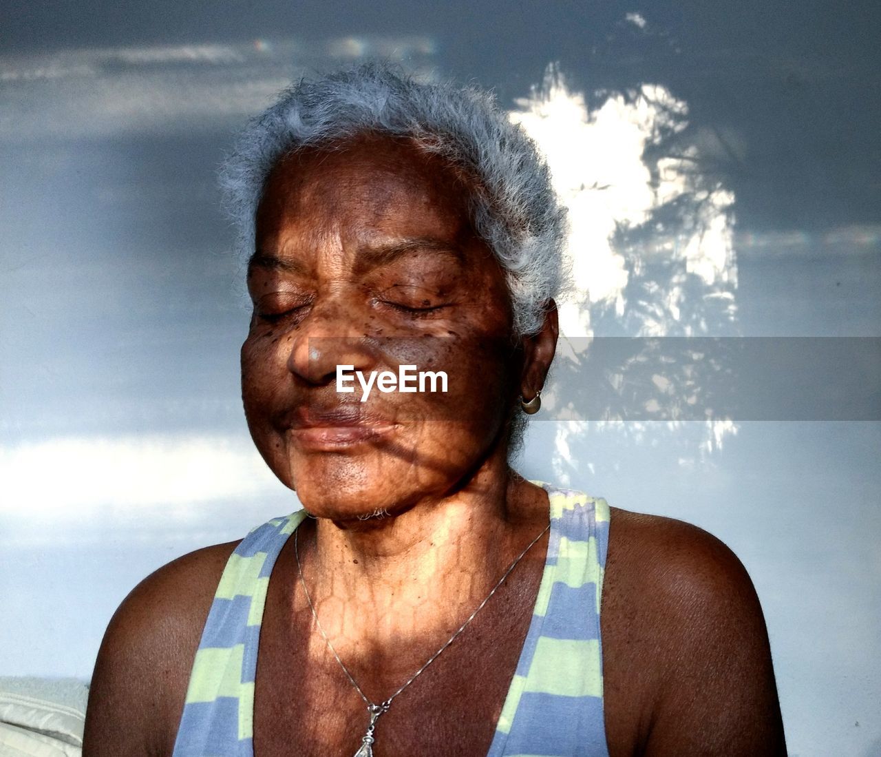 Close-up of senior woman against wall