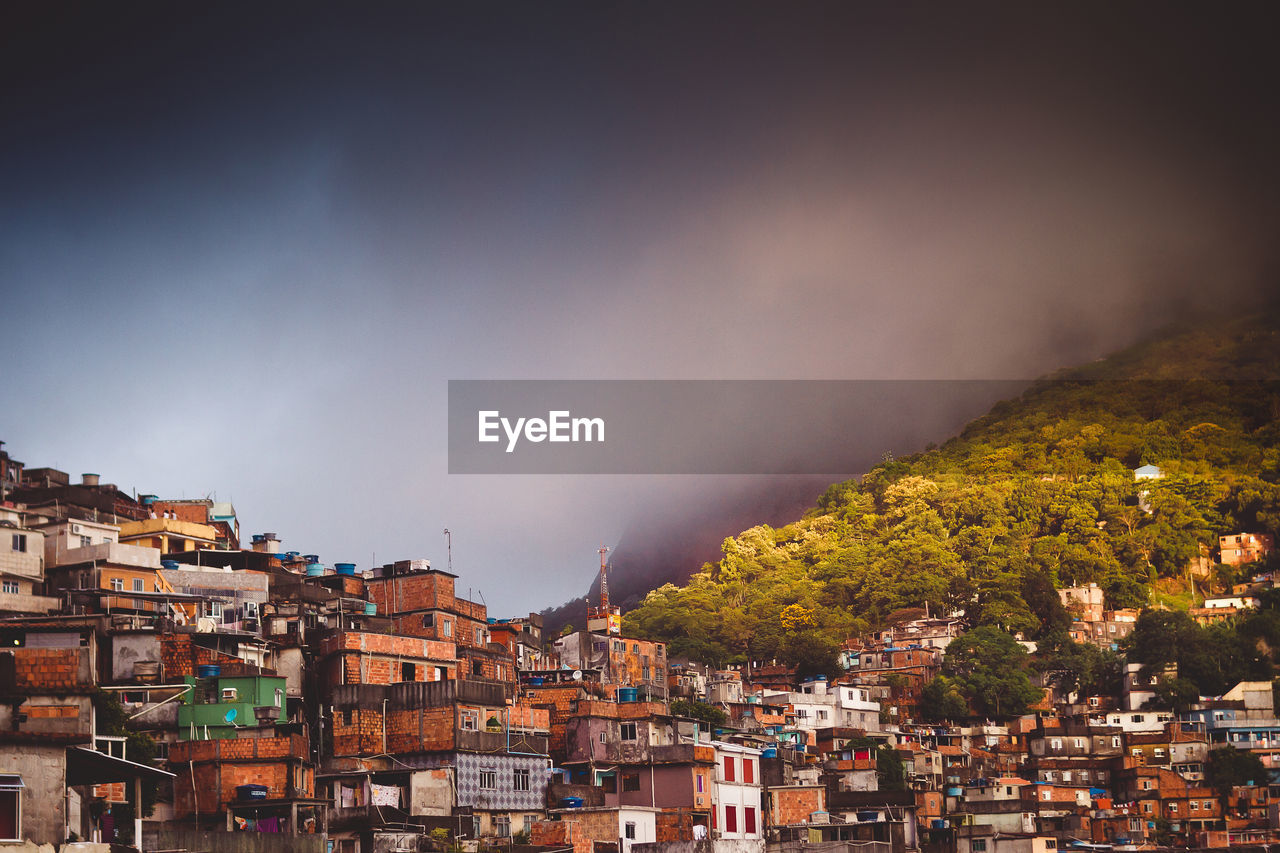 Houses of a slum in city against sky