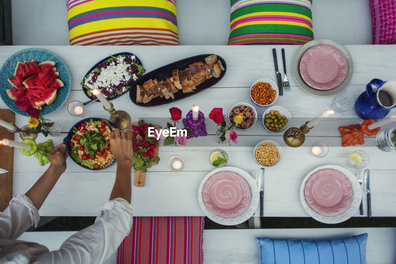 High angle view of young man arranging food on picnic table