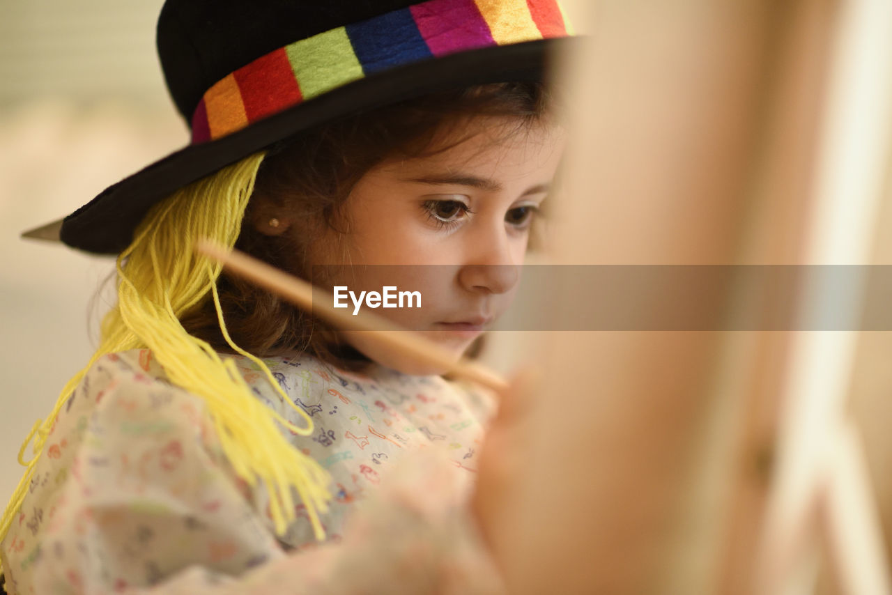 Close-up of cute girl painting at home