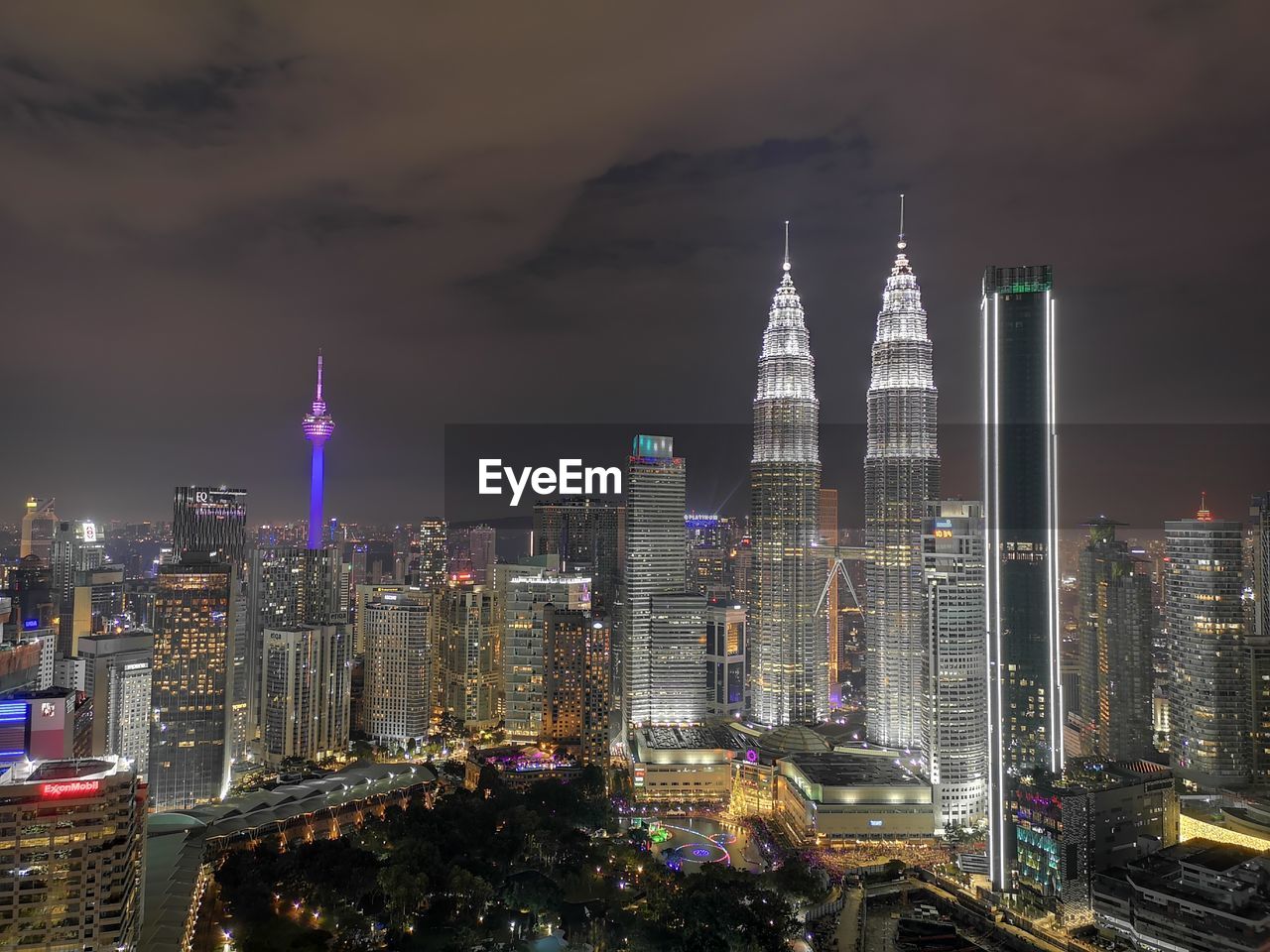 Illuminated modern buildings against sky at night