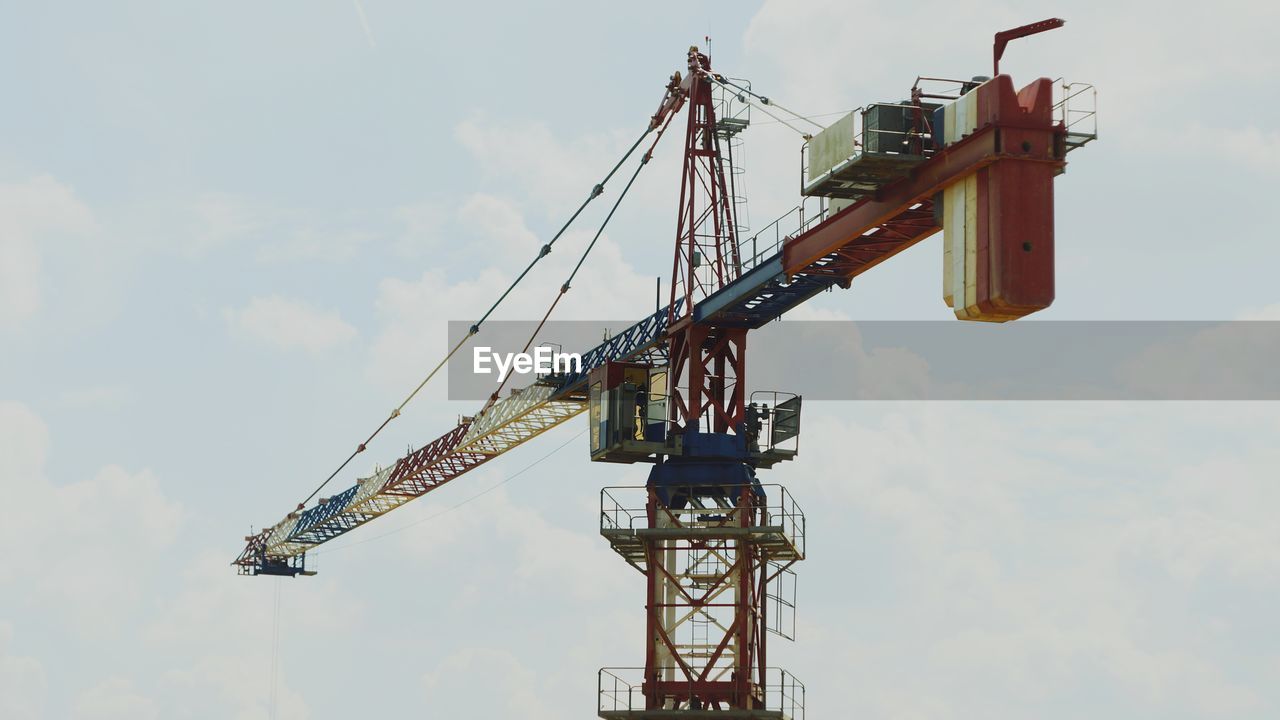 LOW ANGLE VIEW OF CRANES AGAINST SKY