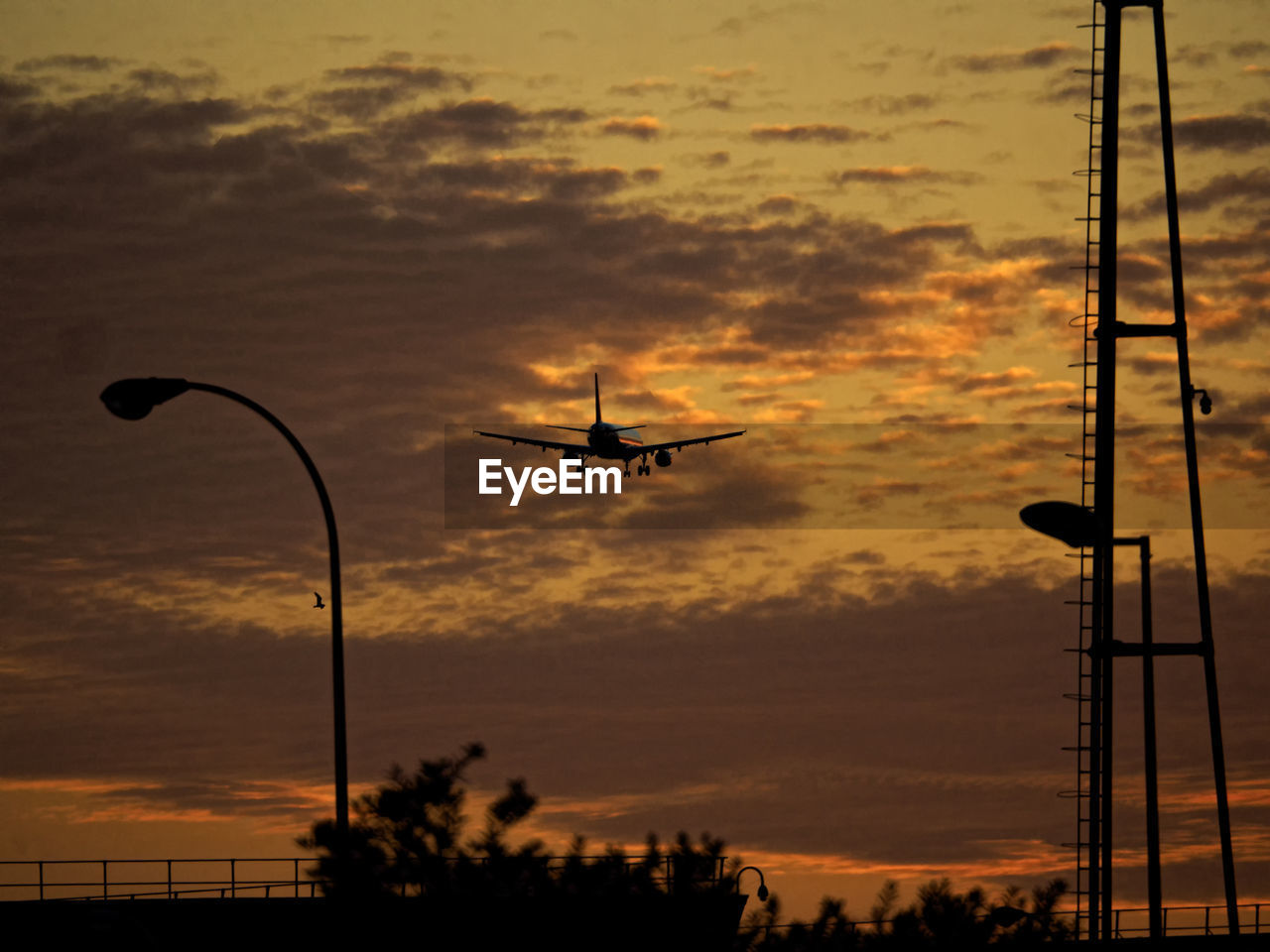 Low angle view of silhouette airplane against sky during sunset