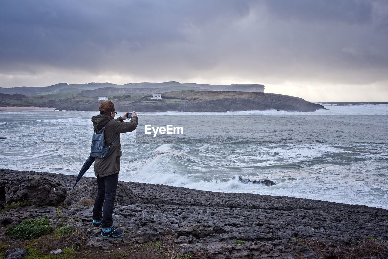 FULL LENGTH OF MAN STANDING ON BEACH