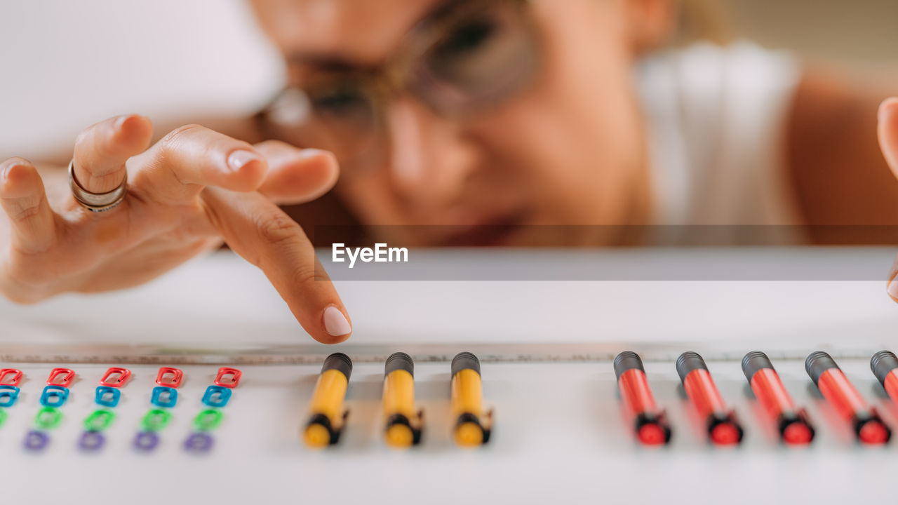 Woman with ocd. obsessive compulsive disorder concept. placing paperclips in a straight line.