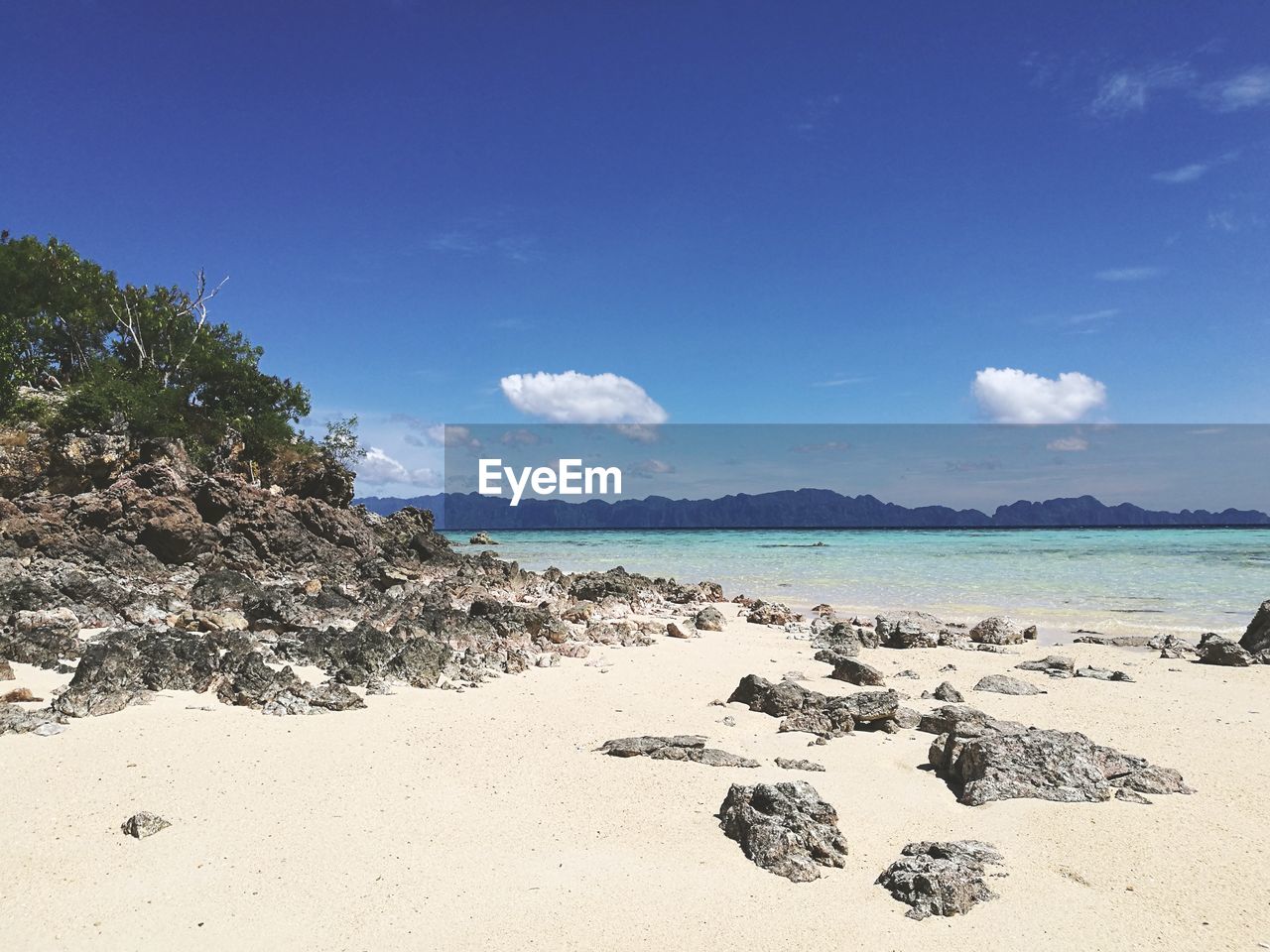 Scenic view of beach against blue sky