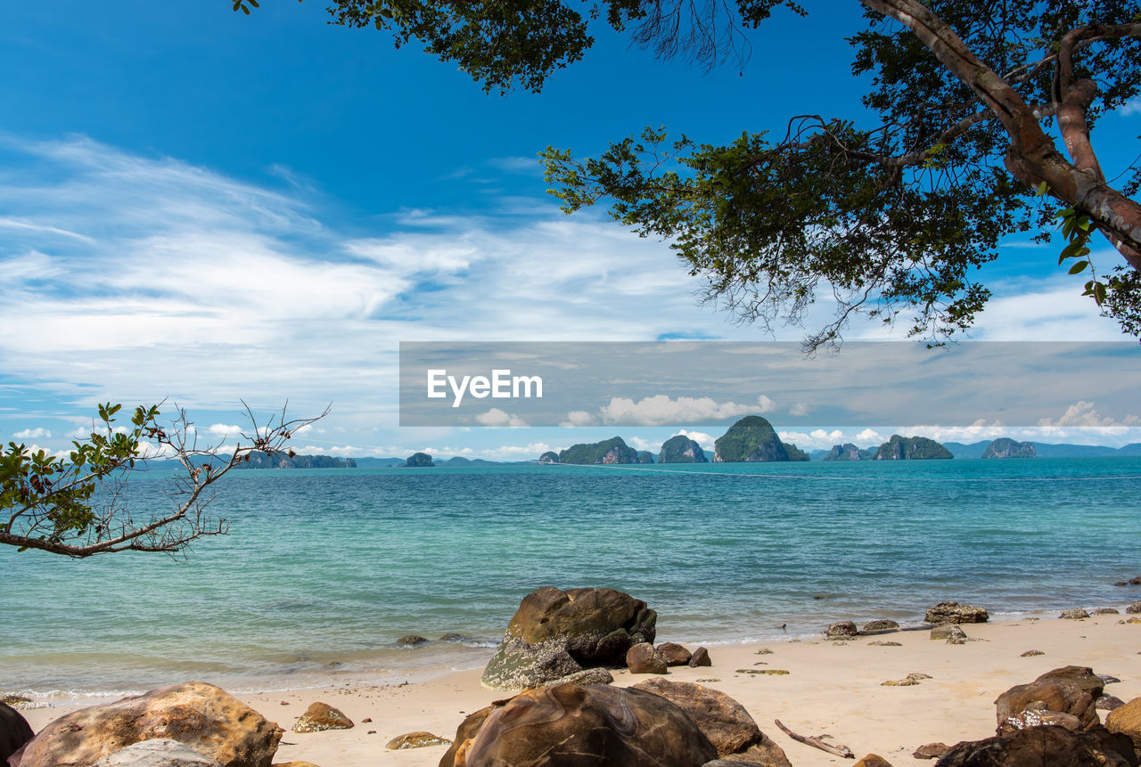 SCENIC VIEW OF ROCKY BEACH AGAINST SKY