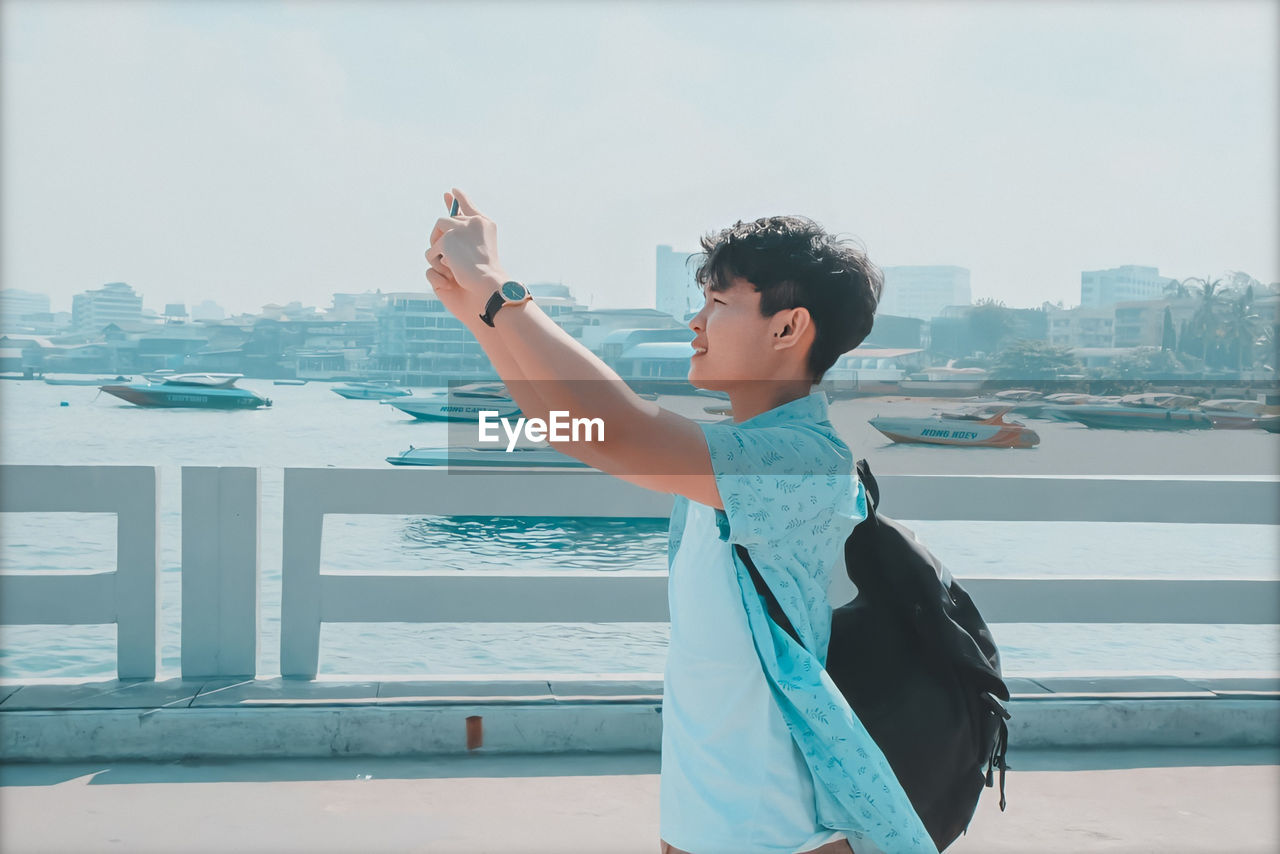 Man photographing while standing in city