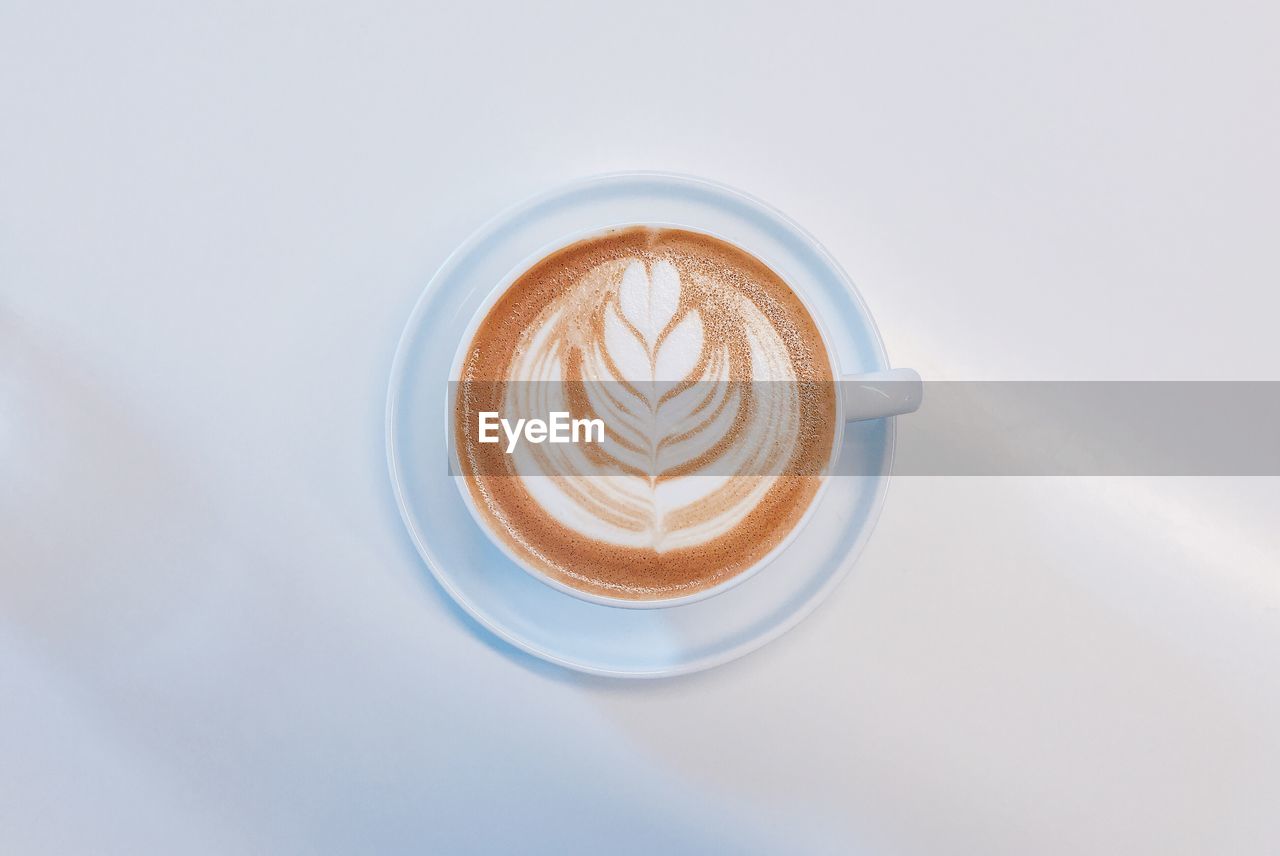 DIRECTLY ABOVE SHOT OF CAPPUCCINO COFFEE CUP WITH WHITE BACKGROUND