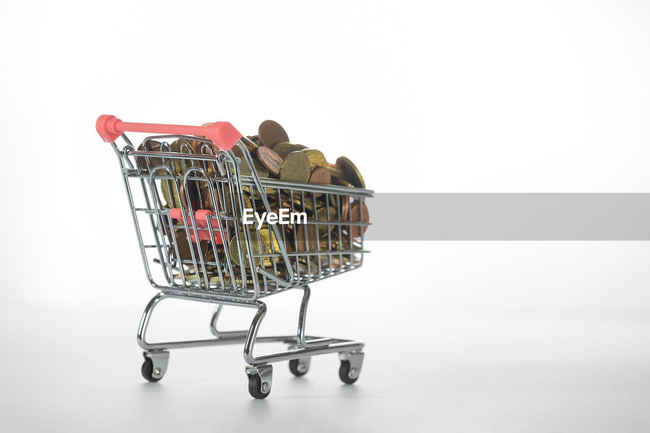 CLOSE-UP OF SHOPPING CART AGAINST GRAY BACKGROUND