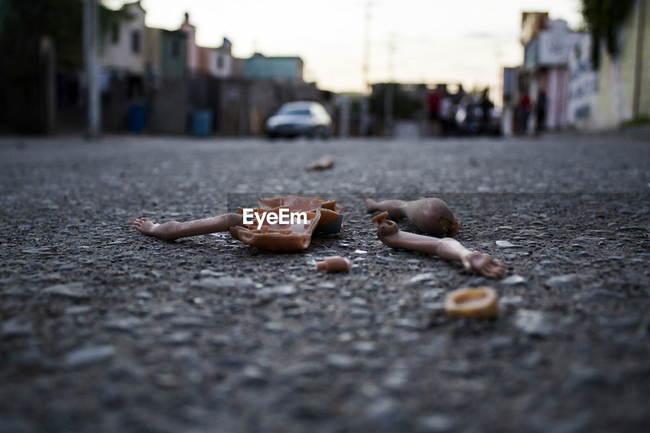 Close-up of broken doll on road