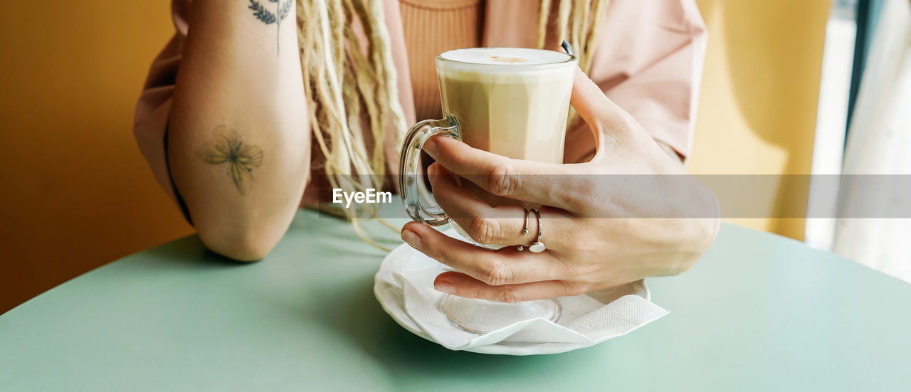 midsection of woman holding coffee cup