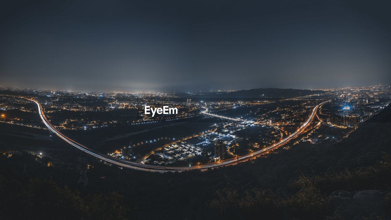 Illuminated cityscape against sky at night