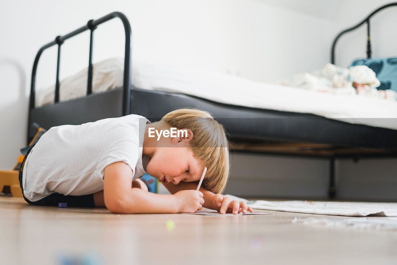 Portrait of boy lying on table